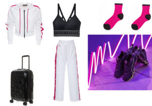 Felpa e pantaloni della linea speciale firmata Elettra Lamborghini / top di Under Armour / valigia 'Travel Duck' di Mandarina Duck / calze Alto Milano / sneakers 'Zone XT' di Puma